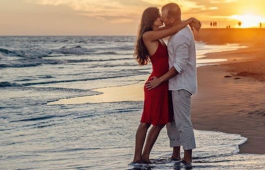 two lovers kissing alongside the beach